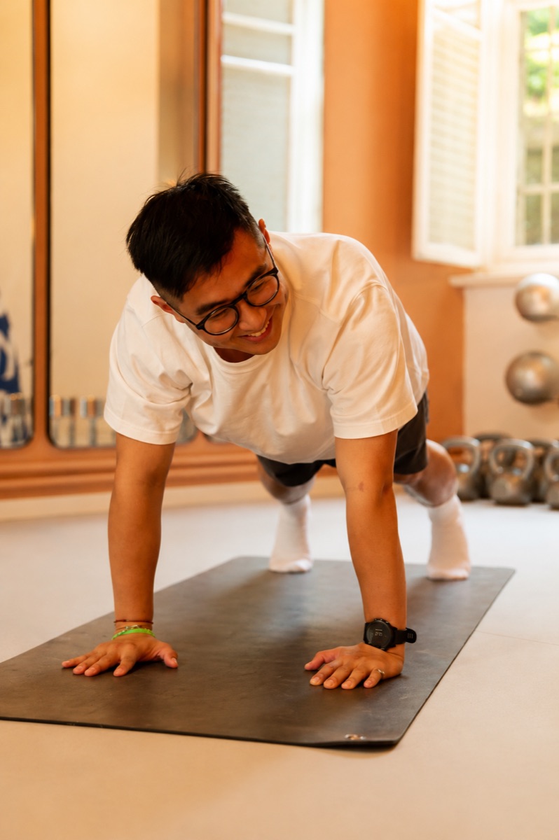 A member smiling mid plank on the mat at Good Moves
